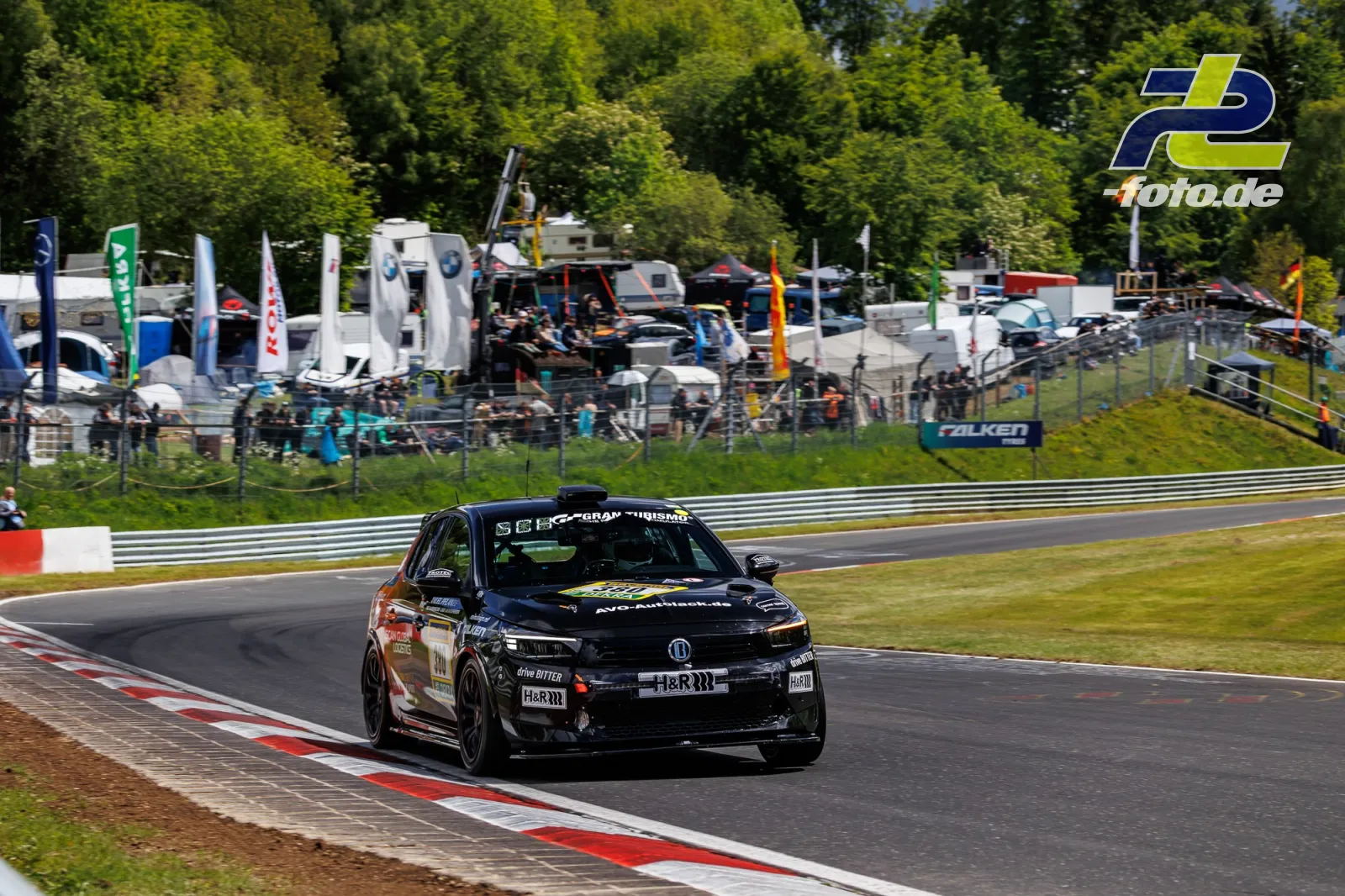 Opel Corsa GS Line 130* auf der Nordschleife beim 24h-Rennen Qualifying, im Hintergrund Fahrerlager und Zuschauer.