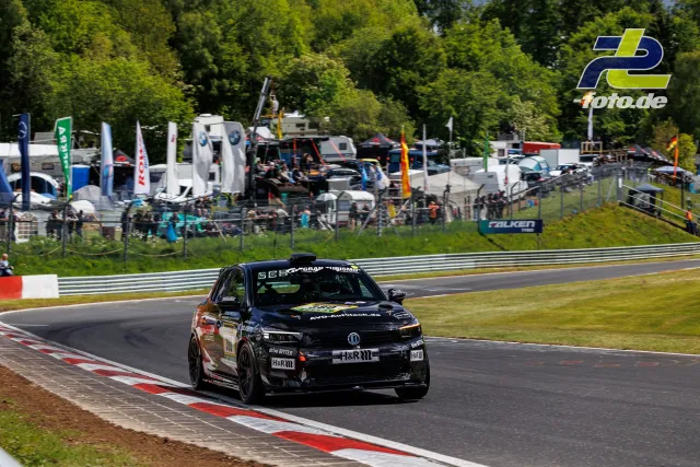 Opel Corsa GS Line 130* auf der Nordschleife beim 24h-Rennen Qualifying, im Hintergrund Fahrerlager und Zuschauer.