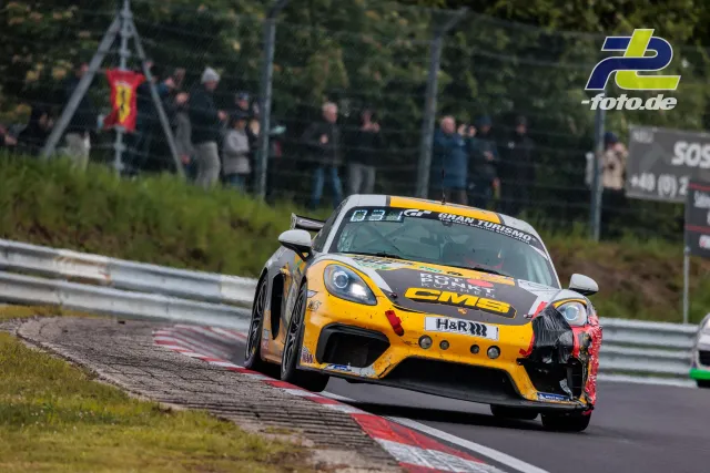 Porsche 718 Cayman GT4 CS in gelb-schwarzer Lackierung während des 24h-Rennens auf der Nordschleife mit Unfallschaden am rechten Frontbereich.