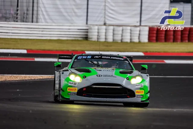 Aston Martin Vantage GT3 in grün-grau mit leuchtenden Scheinwerfern auf der Nürburgring-Nordschleife beim Qualifying zum 24h-Rennen.