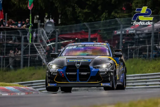 BMW M4 GT4 mit RAVENOL-Lackierung in Frontansicht auf der Nürburgring-Nordschleife während des 24h-Rennens.