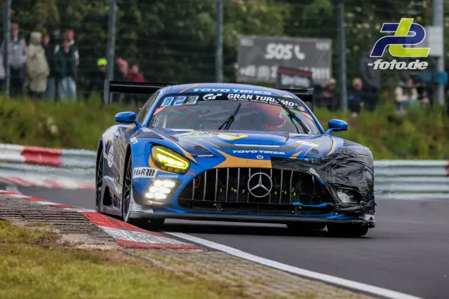 Mercedes-AMG GT3 in blau-orange auf nasser Nordschleife beim 24h-Rennen Nürburgring, Frontansicht mit leichtem Schaden.