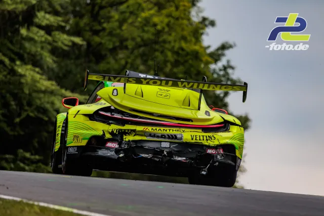 Porsche 911 GT3 R #911 in neongelber Lackierung beim Beschleunigen auf dem Nürburgring während des 24-Stunden-Rennens, Heckansicht.