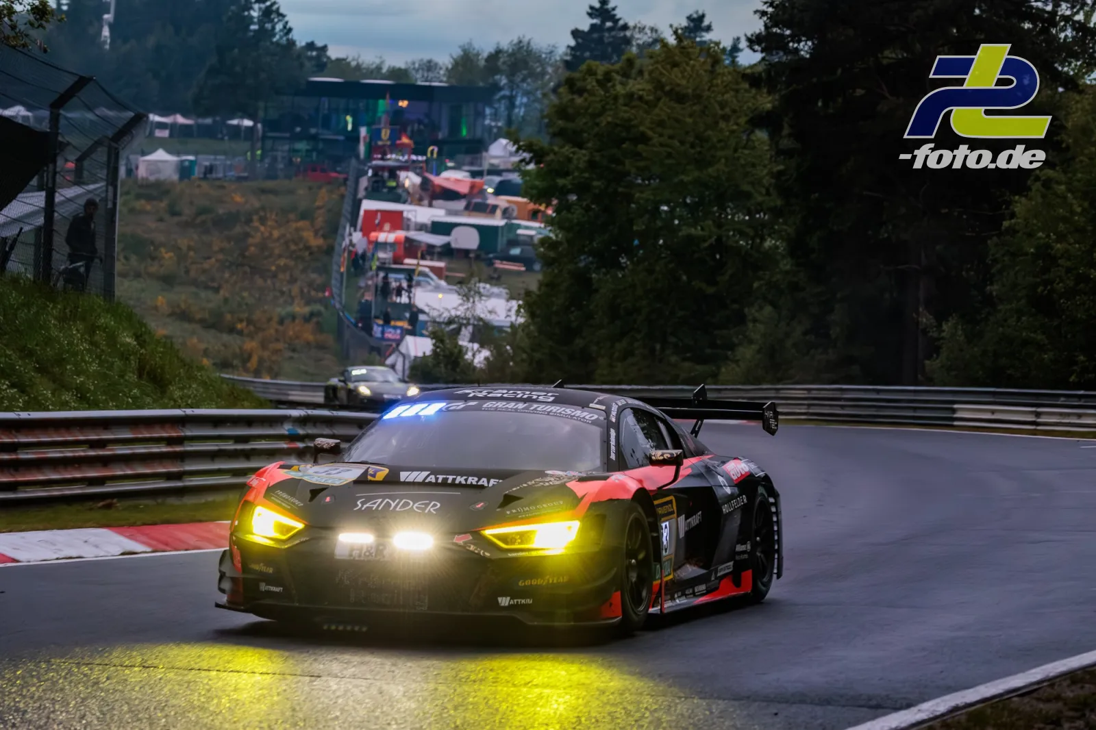 BMW M4 GT3 mit eingeschalteten Scheinwerfern in einer Kurvensektion auf der Nordschleife beim 24h-Rennen Nürburgring