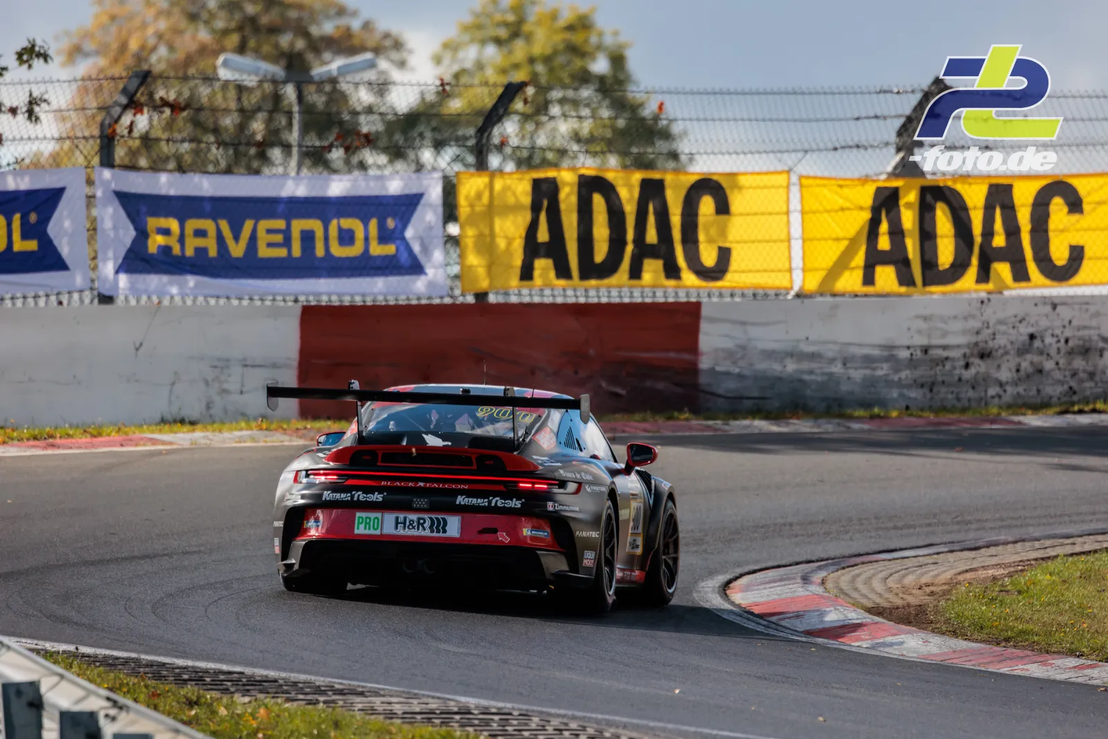 Porsche 911 GT3 Cup von BLACK FALCON Team ZIMMERMANN in der Kurve auf dem Nürburgring während NLS Lauf 10, Heckansicht mit Randstein im Vordergrund