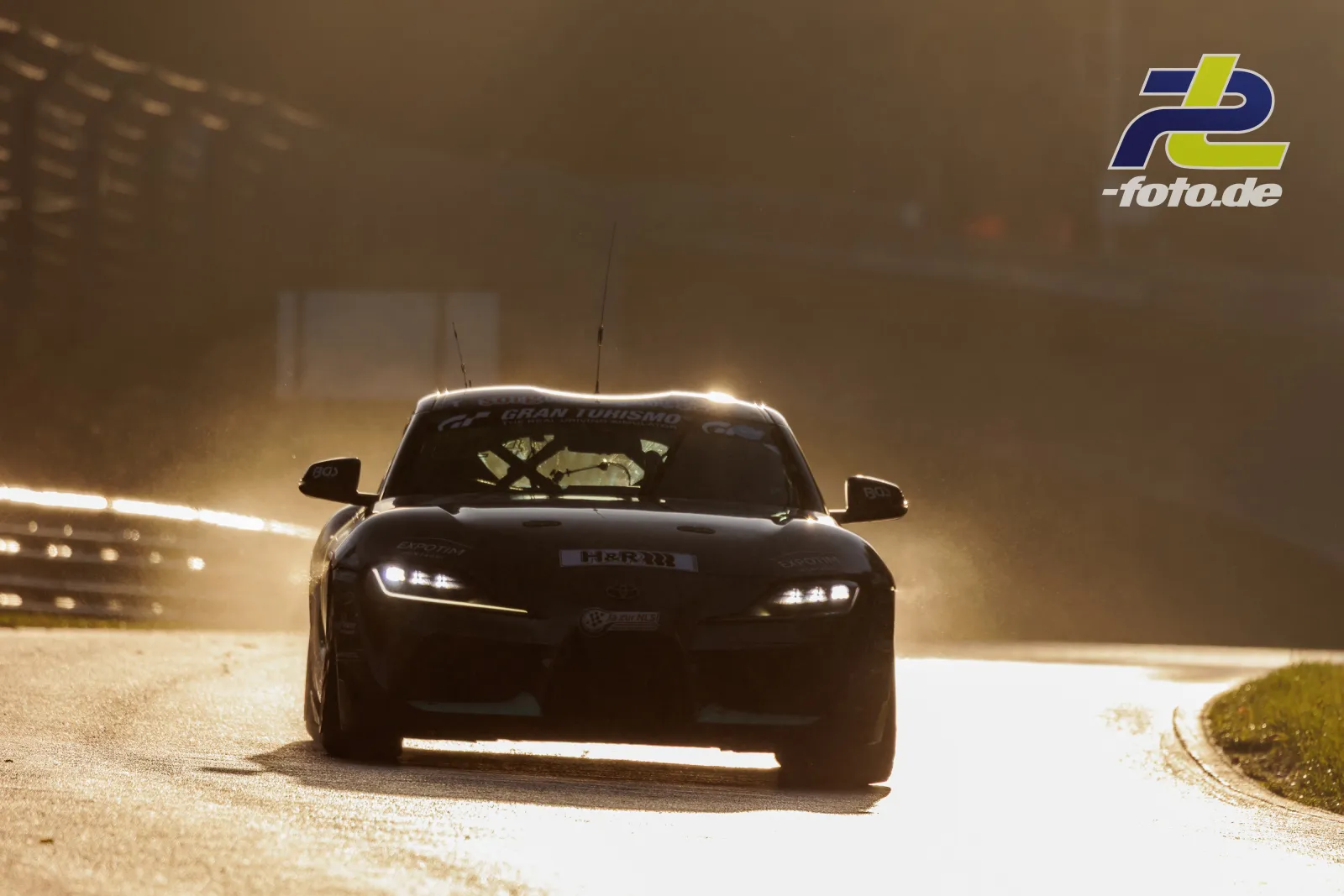 Toyota Supra im Gegenlicht während des Qualifyings auf dem Nürburgring, dramatische Lichtstimmung mit Dunst und Silhouetteneffekt.
