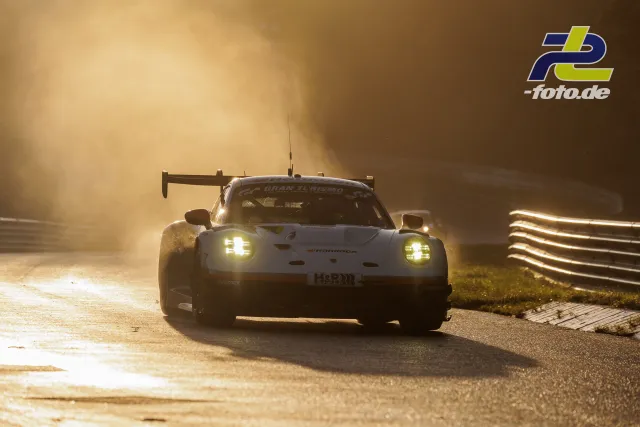 Porsche 911 GT3 R mit eingeschaltetem Licht bei tiefstehender Sonne im starken Gegenlicht auf der Nordschleife des Nürburgrings.