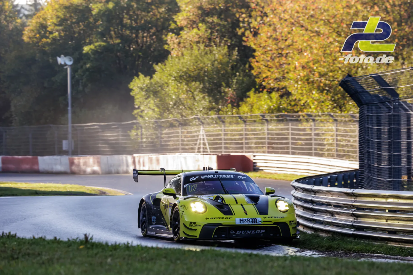 Neongelber Porsche 911 GT3 R mit Startnummer 17 im Qualifying auf der Nürburgring-Nordschleife, herbstliche Baumkulisse.