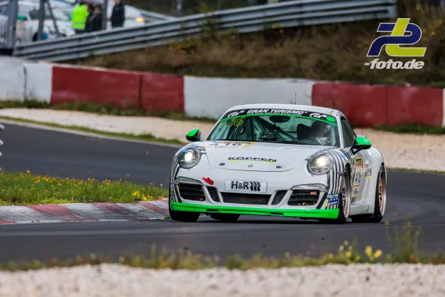 Weißer Porsche 911 mit grünen Akzenten auf der Nordschleife während der 2. NLS Sportwarte-Trophy am Nürburgring.