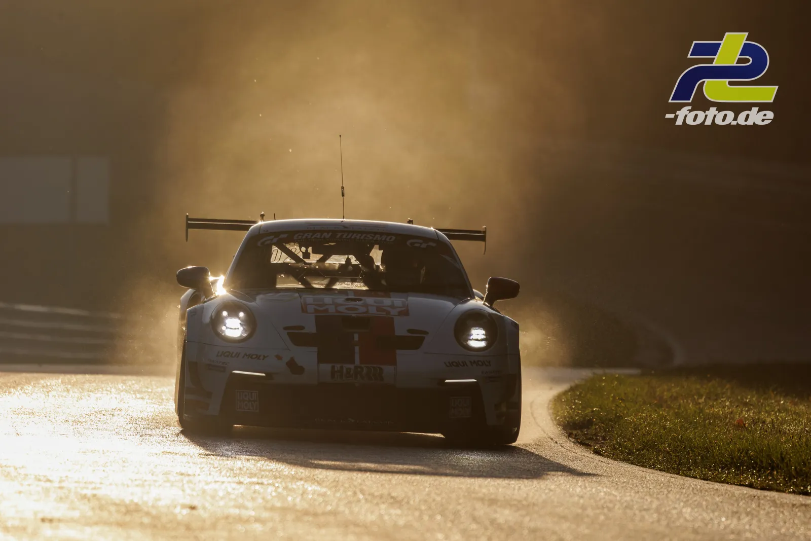 Porsche 911 GT3 Cup im Gegenlicht während des Qualifyings auf dem Nürburgring, frontale Aufnahme mit eingeschalteten Scheinwerfern