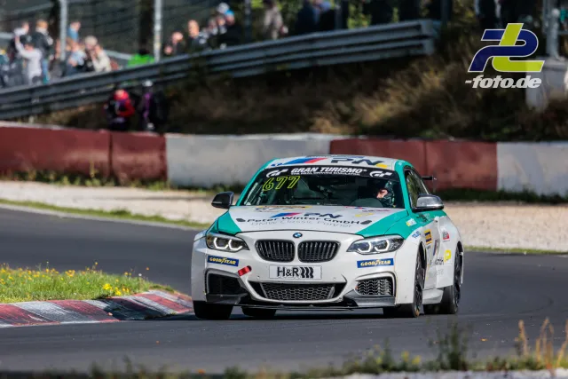 BMW M240i Nummer 677 in weiß-türkiser Lackierung auf der Nordschleife des Nürburgrings während der NLS Sportwarte-Trophy.