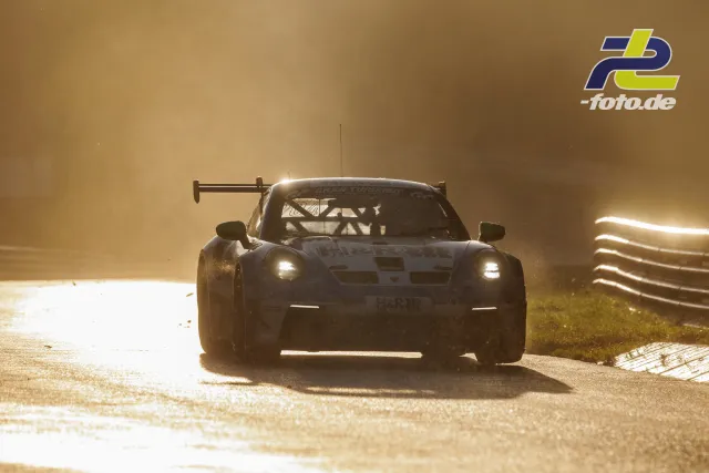 GT3-Rennwagen von hinten im starken Gegenlicht und Nebel auf der Nordschleife während des Qualifyings.