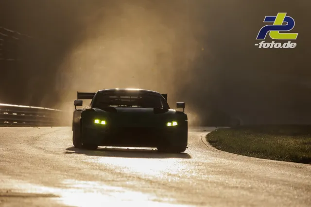GT3-Rennwagen mit gelben Scheinwerfern im Gegenlicht bei nebligem Wetter auf dem Nürburgring während des Qualifyings.
