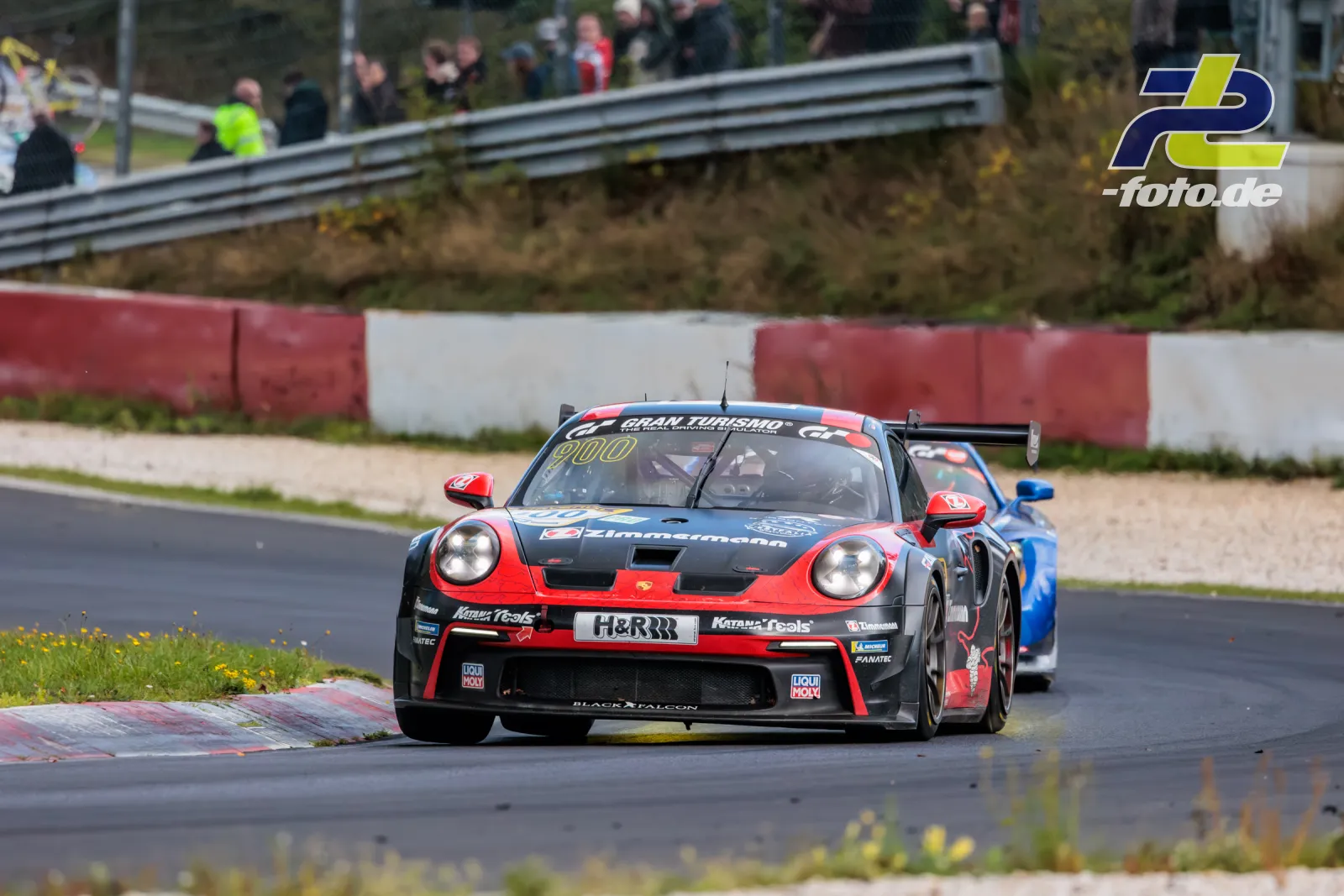Porsche 911 GT3 Cup mit Startnummer 900 auf der Nordschleife des Nürburgrings, gefolgt von einem blauen Fahrzeug.