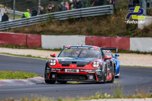 Porsche 911 GT3 Cup mit Startnummer 900 auf der Nordschleife des Nürburgrings, gefolgt von einem blauen Fahrzeug.