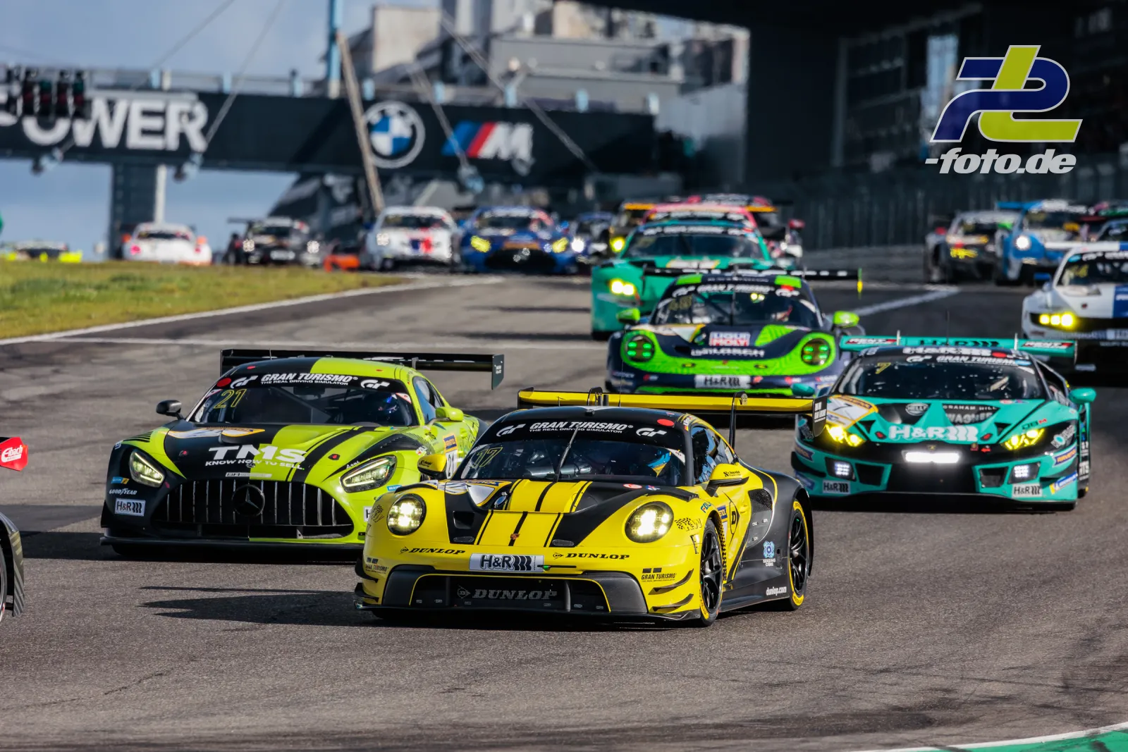 GT3-Feld auf der Start-Ziel-Geraden des Nürburgrings während der Einführungsrunde, angeführt von gelbem Sportwagen.