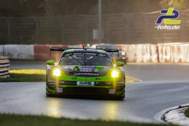 Porsche 911 GT3 R #48 in neongrün-schwarzer Lackierung mit eingeschalteten Scheinwerfern beim Qualifying auf dem Nürburgring.