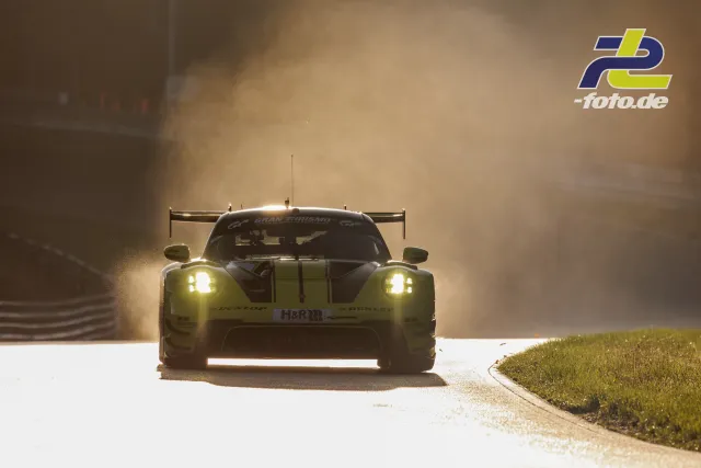 Rennwagen von hinten im Gegenlicht bei feuchten Bedingungen auf dem Nürburgring, Gischt und Nebel