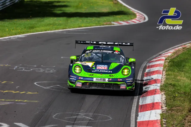 Porsche 911 GT3 R mit neongrüner Lackierung in Frontalansicht auf der Nordschleife des Nürburgrings während des Rennens.