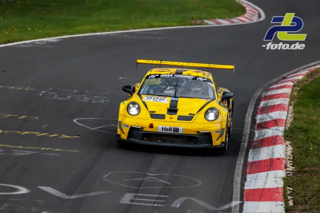 Gelber Porsche 911 GT3 Cup #906 in einer Kurve der Nürburgring-Nordschleife während des NLS-Rennens.