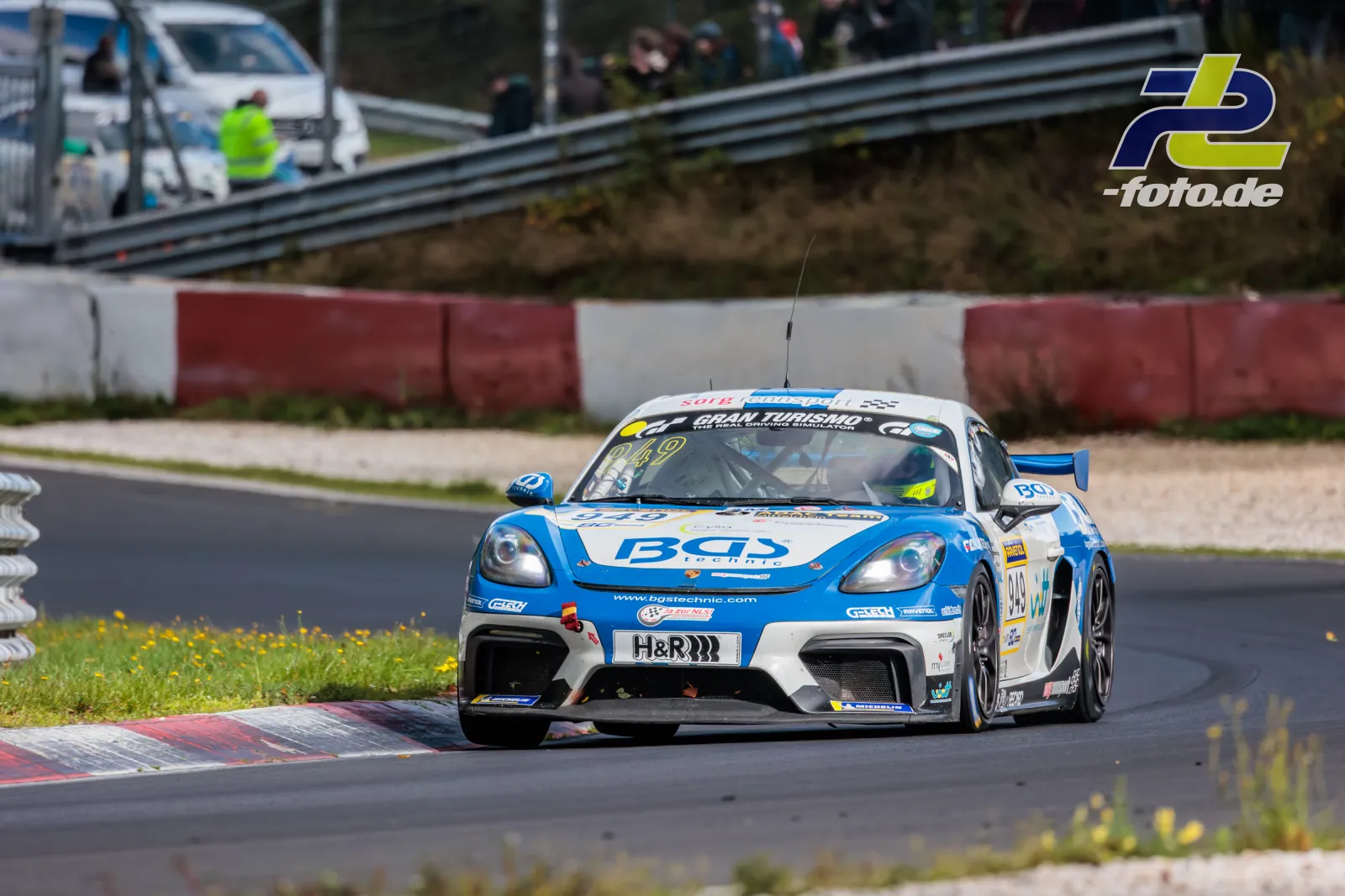 Porsche 718 Cayman GT4 CS #949 in blau-weißer Lackierung in der Kurve auf der Nordschleife beim NLS-Rennen am Nürburgring.
