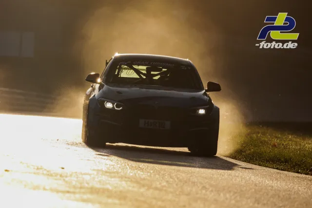 Rennwagen bei der NLS im Gegenlicht mit Staubwolke am Randstein während des Qualifyings auf dem Nürburgring.