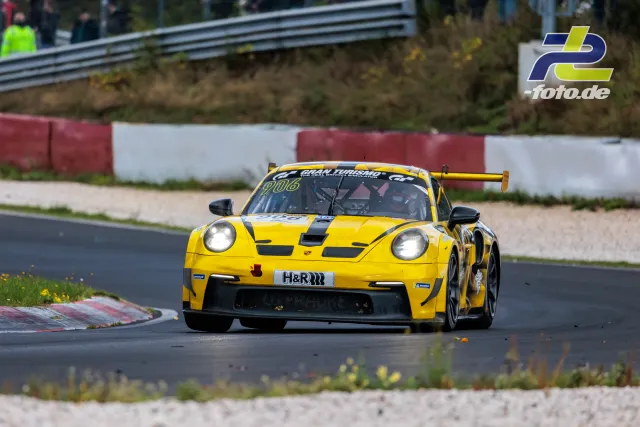 Gelber Porsche 911 GT3 R mit schwarzen Streifen in Kurvenausfahrt am Nürburgring, NLS Rennen