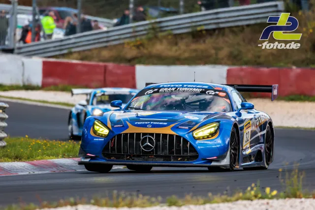 Mercedes-AMG GT3 Nummer 32 in Blau-Orange auf dem Nürburgring während des NLS-Rennens, gefolgt von einem zweiten Fahrzeug.