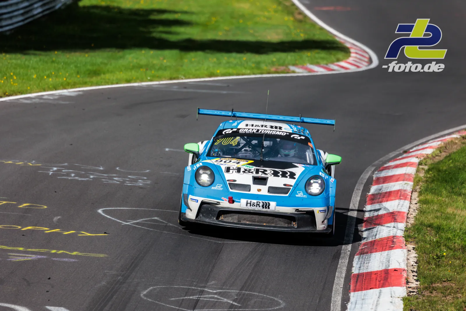 Porsche 911 GT3 Cup in hellblau-weißer Lackierung in einer Kurve auf dem Nürburgring Nordschleife während des Rennens.