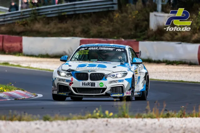 BMW M240i Racing mit Startnummer 652 auf der Nordschleife während des Rennens, weiß-blaue Lackierung mit WAGI-TECHNIK-Sponsoring.