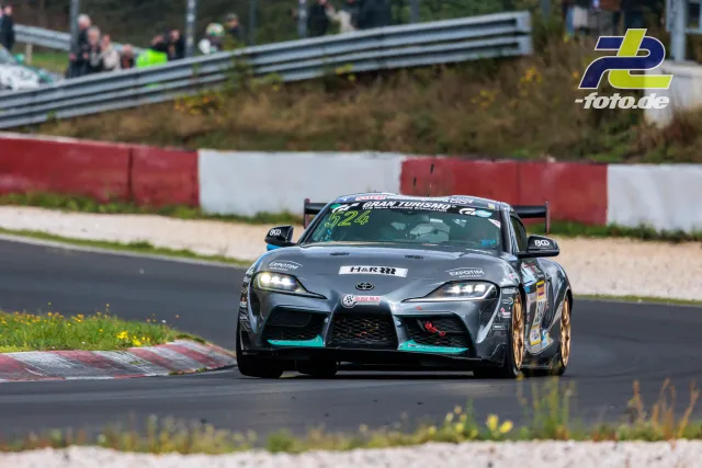 Toyota Supra mit Startnummer 524 in Kurve auf der Nordschleife, grau-türkise Lackierung mit goldfarbenen Felgen