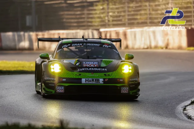 Porsche 911 GT3 R in giftgrün-grauer Lackierung mit eingeschalteten Scheinwerfern im Qualifying auf dem Nürburgring.