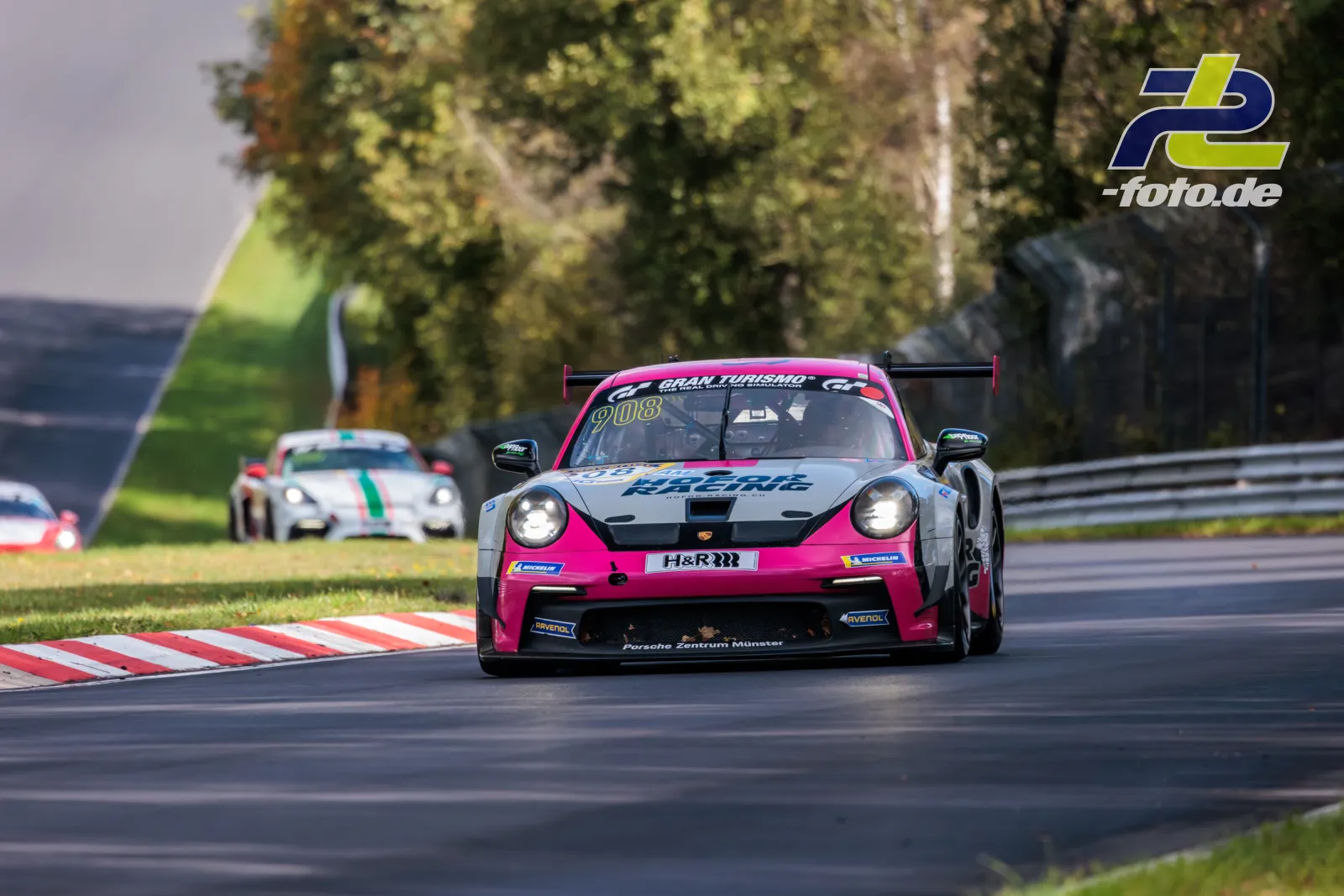 Porsche 911 GT3 Cup in Pink und Weiß auf der Nordschleife beim NLS Rennen, Herbstbäume im Hintergrund