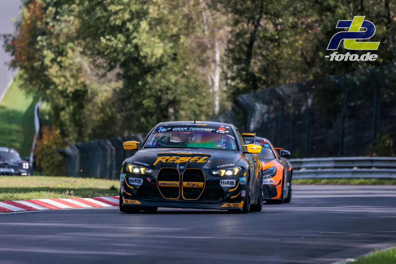BMW M4 GT3 in schwarz-gelber RSBEL-Lackierung führt das Feld an, gefolgt von einem orangefarbenen Fahrzeug auf dem Nürburgring.