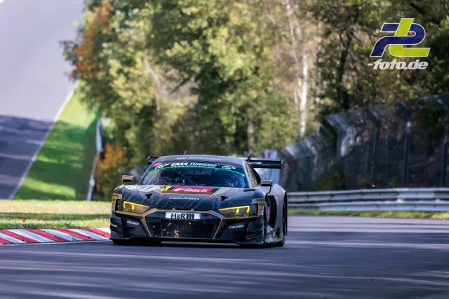 Audi R8 LMS GT3 in grauer Lackierung mit gelben Scheinwerfern auf der Nordschleife, Herbst, Rennsituation.
