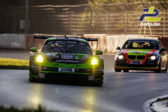 Porsche 911 GT3 R in grün-schwarz und BMW in rot-grün mit eingeschalteten Scheinwerfern auf der Nordschleife beim Qualifying.