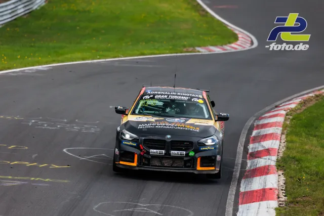 BMW M2 Nummer 870 in Kurve auf der Nürburgring Nordschleife während NLS Rennen, Frontansicht.