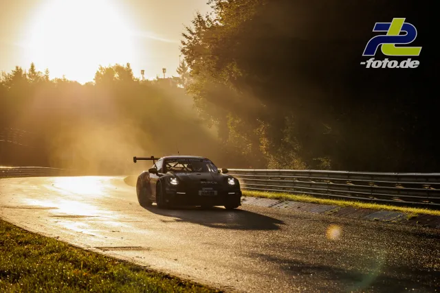 Porsche GT3-Rennwagen im dramatischen Gegenlicht auf der Nordschleife während des Qualifyings.