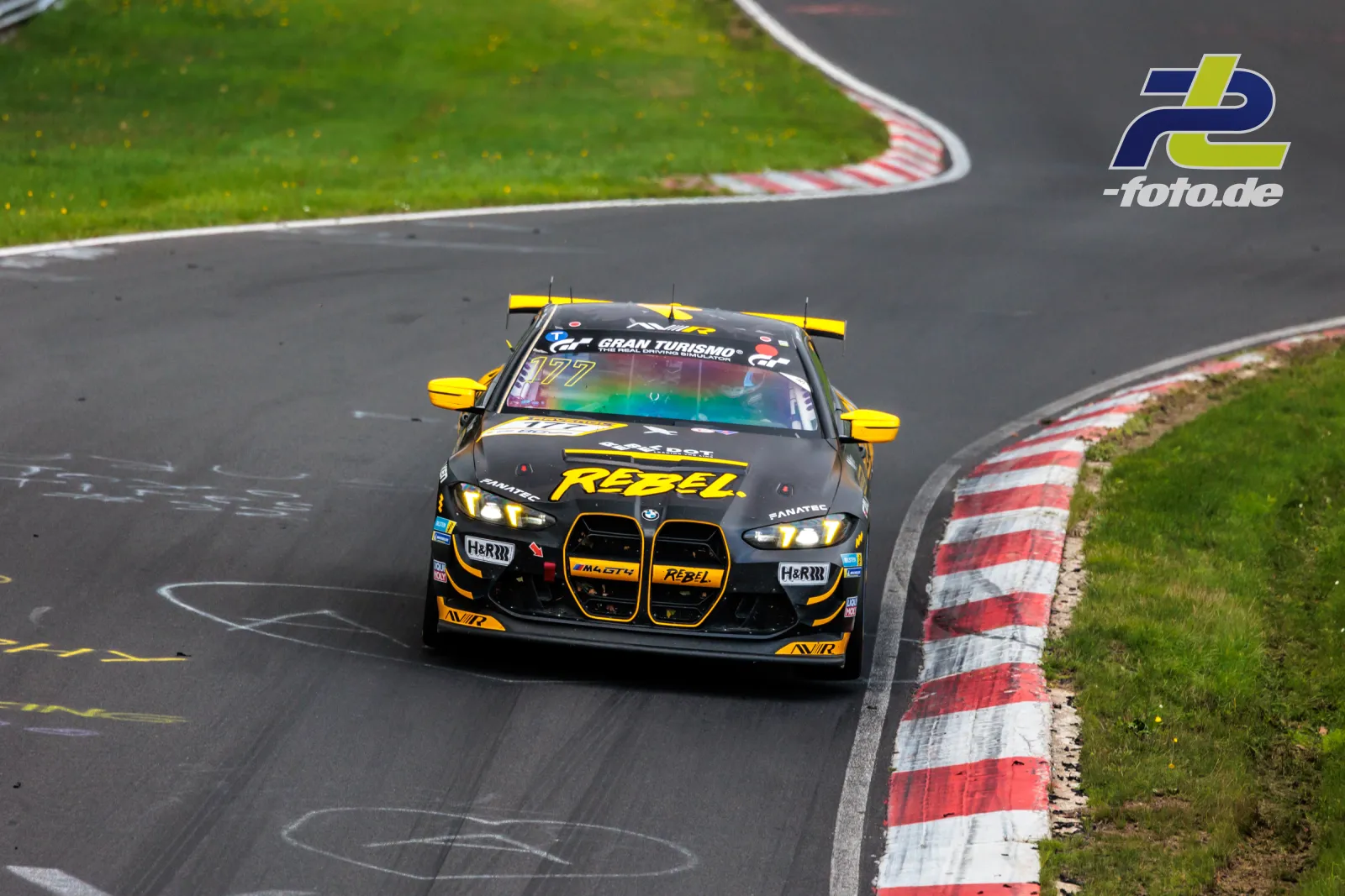 BMW M4 GT3 Nummer 177 in schwarz-gelber Lackierung in einer Kurve der Nürburgring Nordschleife während des NLS-Rennens.