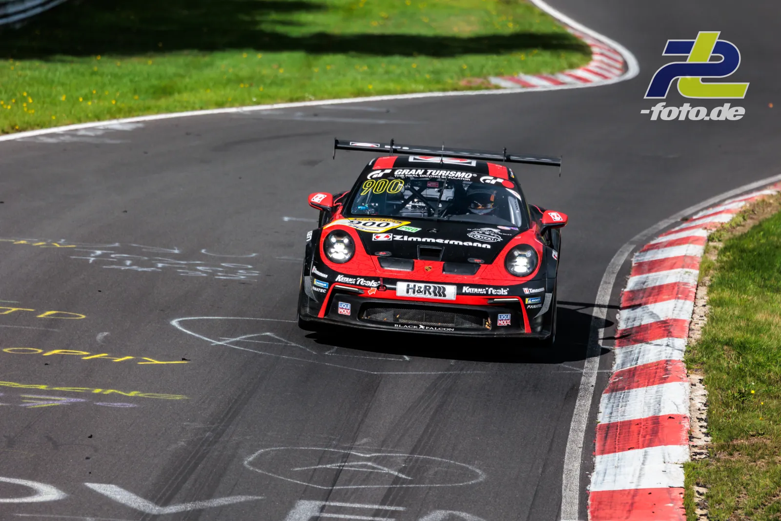 Porsche 911 GT3 Cup in rot-schwarz auf der Nürburgring-Nordschleife während des Rennens, Frontalansicht in einer Kurve.