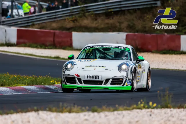 Weißer Porsche 911 mit neongrünen Akzenten und Startnummer 476 in Kurve auf der Nordschleife des Nürburgrings.