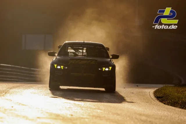 GT-Rennwagen in dramatischem Gegenlicht und Gischt auf dem Nürburgring während des Qualifyings zur NLS Sportwarte-Trophy.