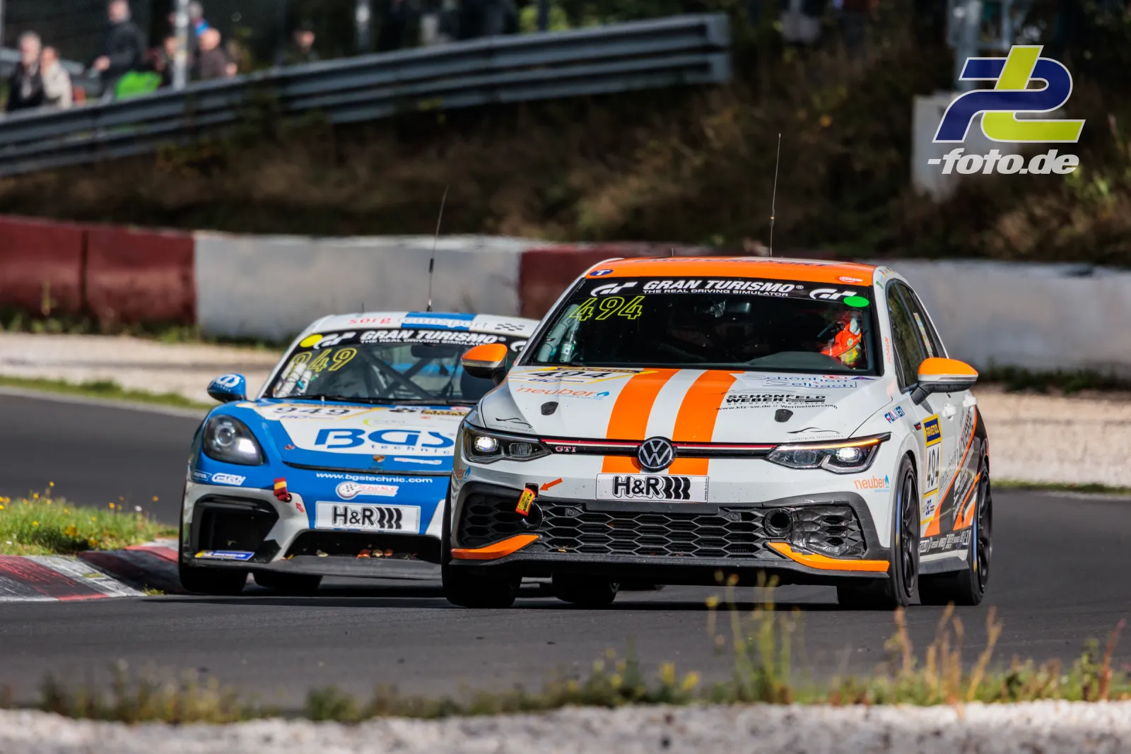VW Golf VIII GTI Clubsport #494 im Zweikampf beim NLS-Rennen auf dem Nürburgring, gefolgt von einem Porsche Cayman.