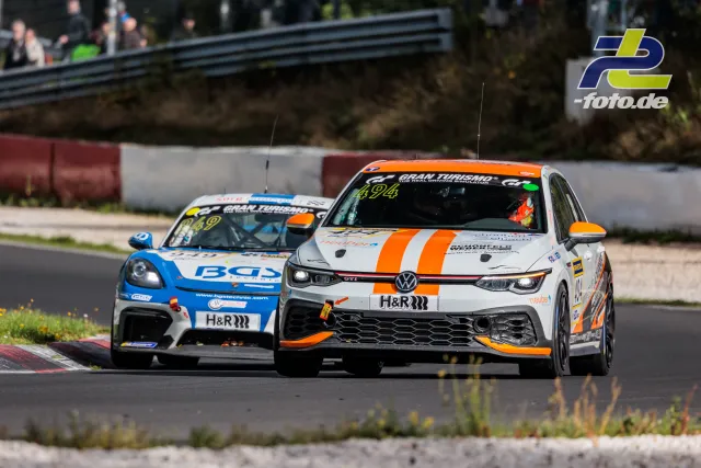 Zweikampf zwischen VW Polo GTI und Porsche Cayman im Rennen auf dem Nürburgring, beide mit H&R-Sponsoring