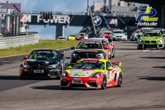 Fahrzeugfeld auf der Nordschleife bei der Einführungsrunde, angeführt von einem Porsche Cayman und BMW-Fahrzeugen.