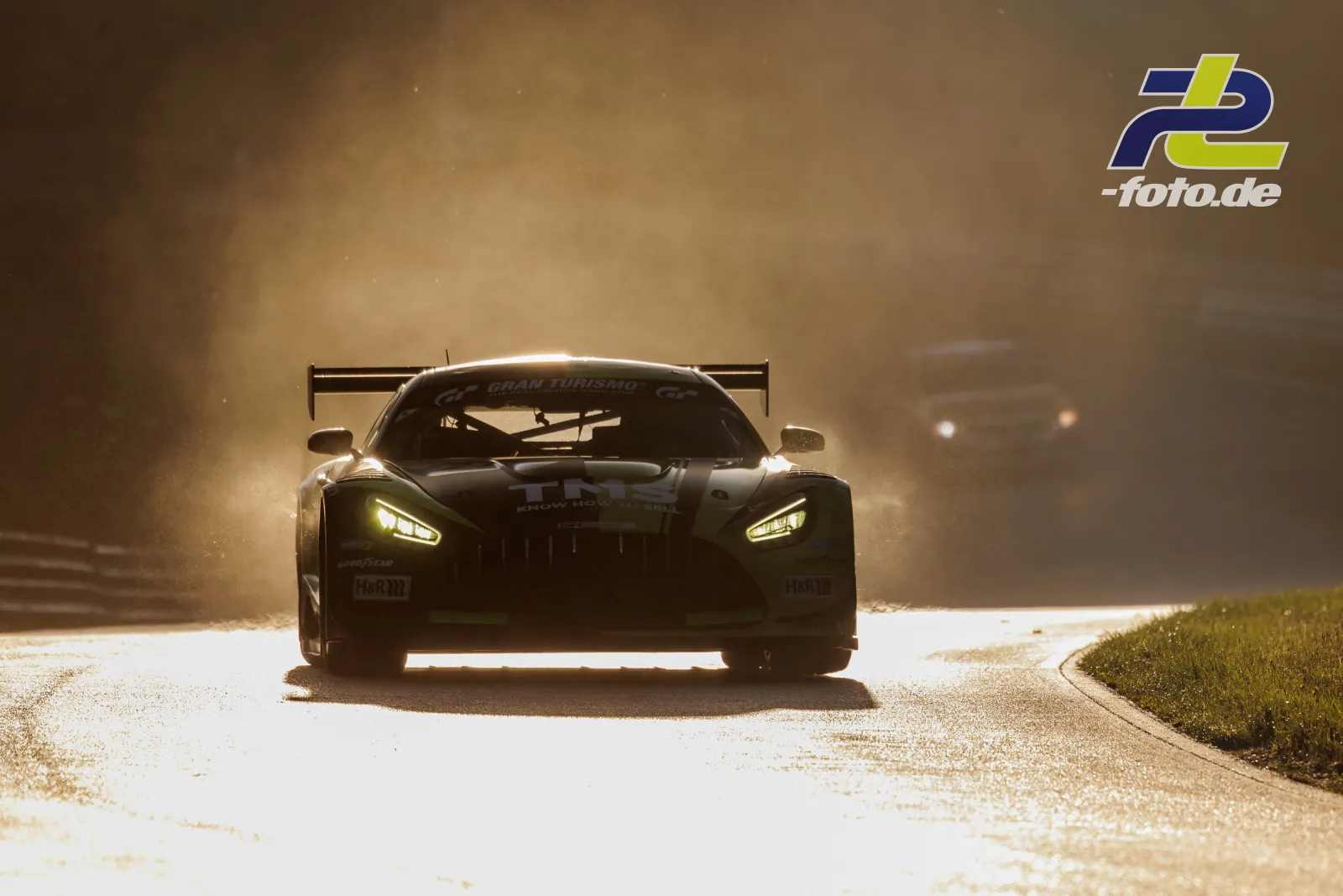 Mercedes-AMG GT3 im Gegenlicht auf dem Nürburgring während des Qualifyings, Frontalansicht mit aufgewirbeltem Staub und leuchtenden Scheinwerfern