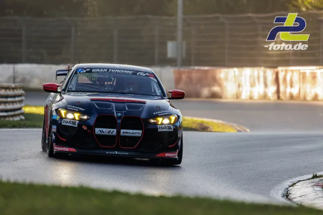 Schwarzer BMW M4 GT4 mit roten Akzenten in einer Kurve während des Qualifyings beim NLS-Lauf am Nürburgring.