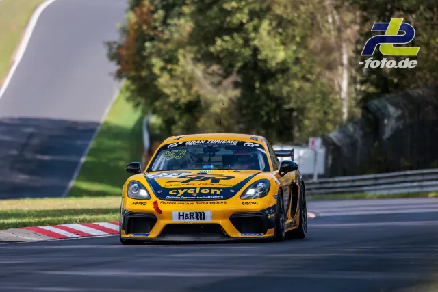 Gelber Porsche 718 Cayman GT4 #953 in einer Kurve auf dem Nürburgring während des NLS-Rennens.