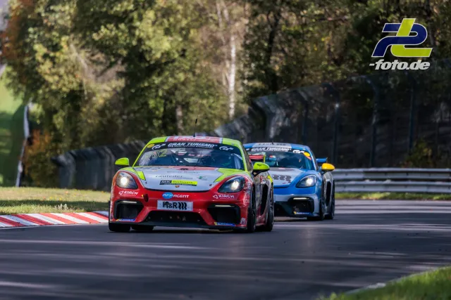 Zwei Porsche 718 Cayman GT4 Clubsport im Zweikampf auf der Nordschleife, führender Wagen in rot-grün mit Startnummer 72.