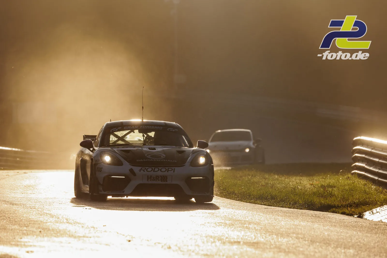 Porsche Cayman 718 GT4 RS im Gegenlicht während des Qualifyings beim NLS-Lauf am Nürburgring, ein weiteres Fahrzeug folgt im Hintergrund.